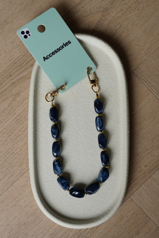 Gouden telefoonkoord met donkerblauwe bedels en gouden details