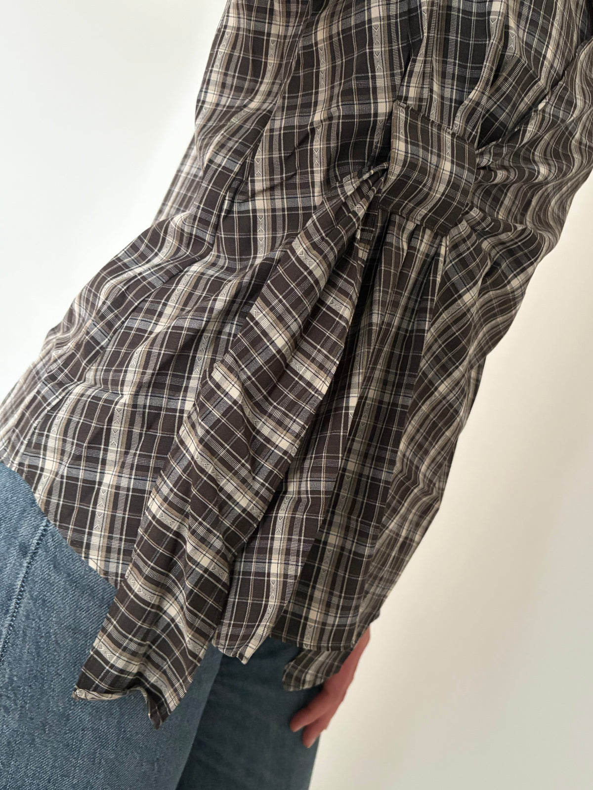 Detailfoto van de bruine blouse met ruitpatroon
