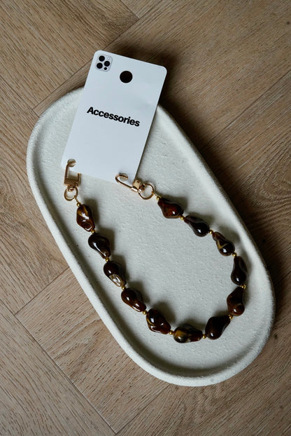 Telefoonkoord met bruine grafisch gevormde bedels en gouden details