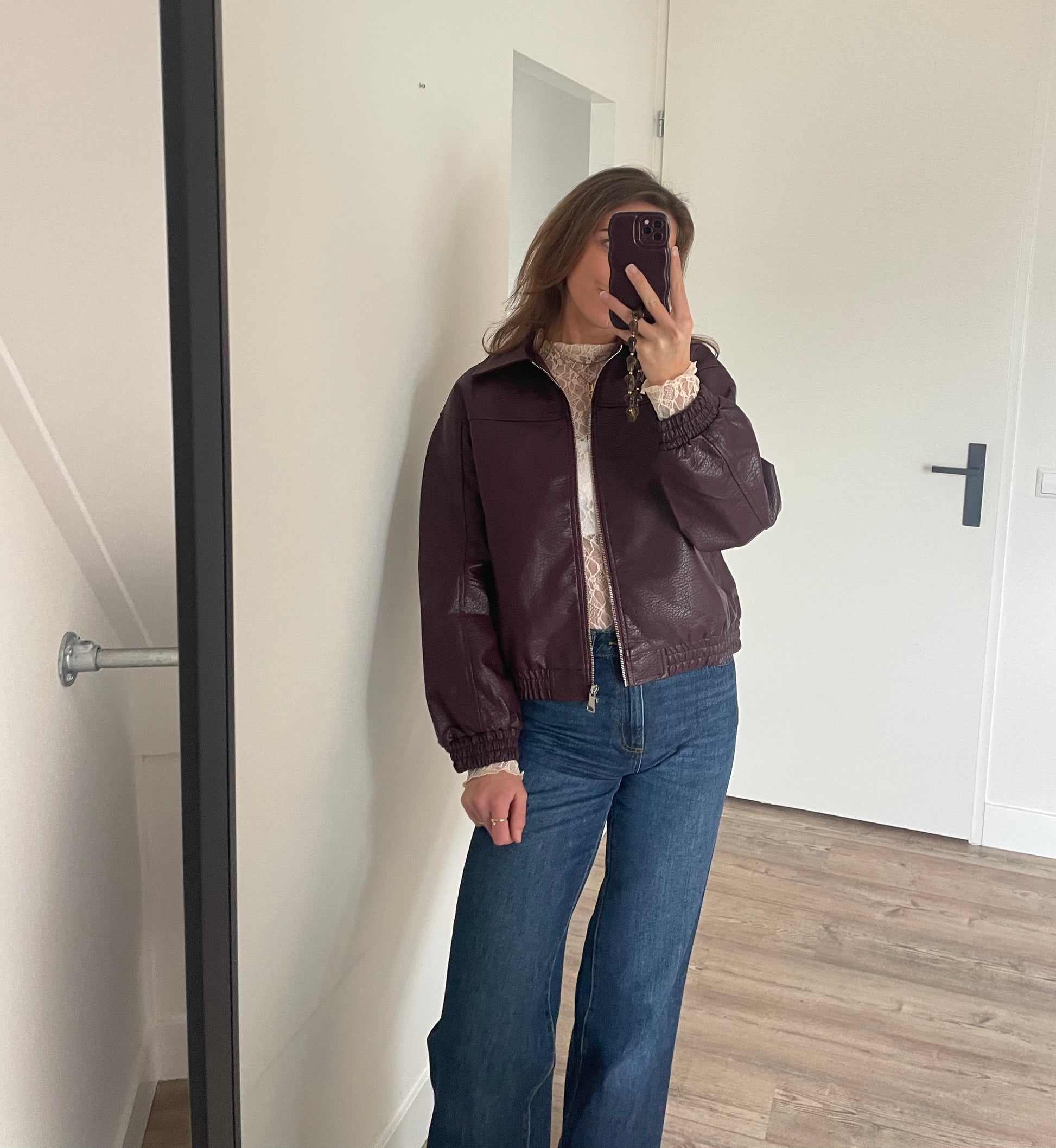 OOTD stijl een leren burgundy bomer met een lace top en wide leg jeans