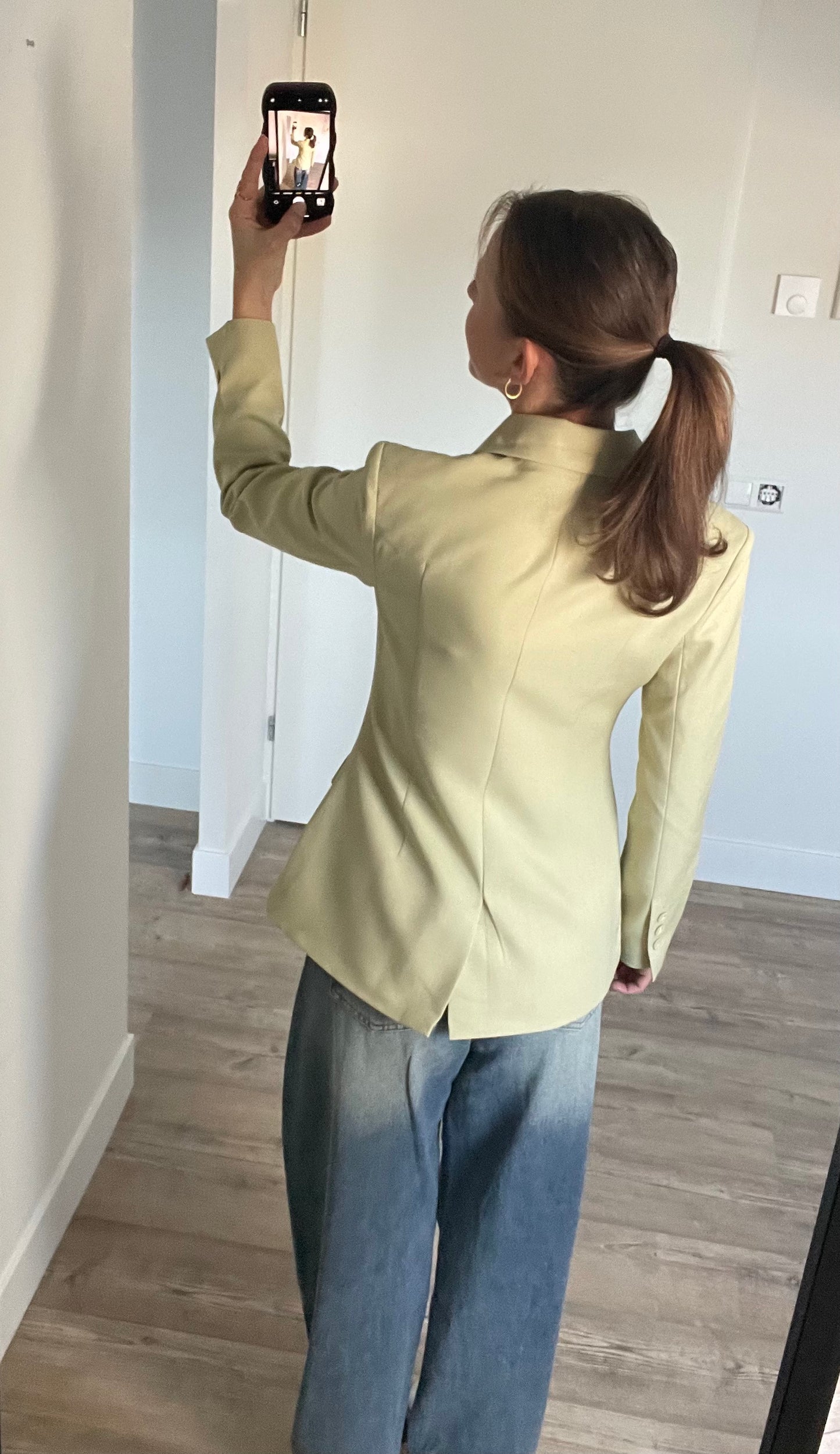 Achterkant van tailored blazer, casual look gecombineerd met jeans