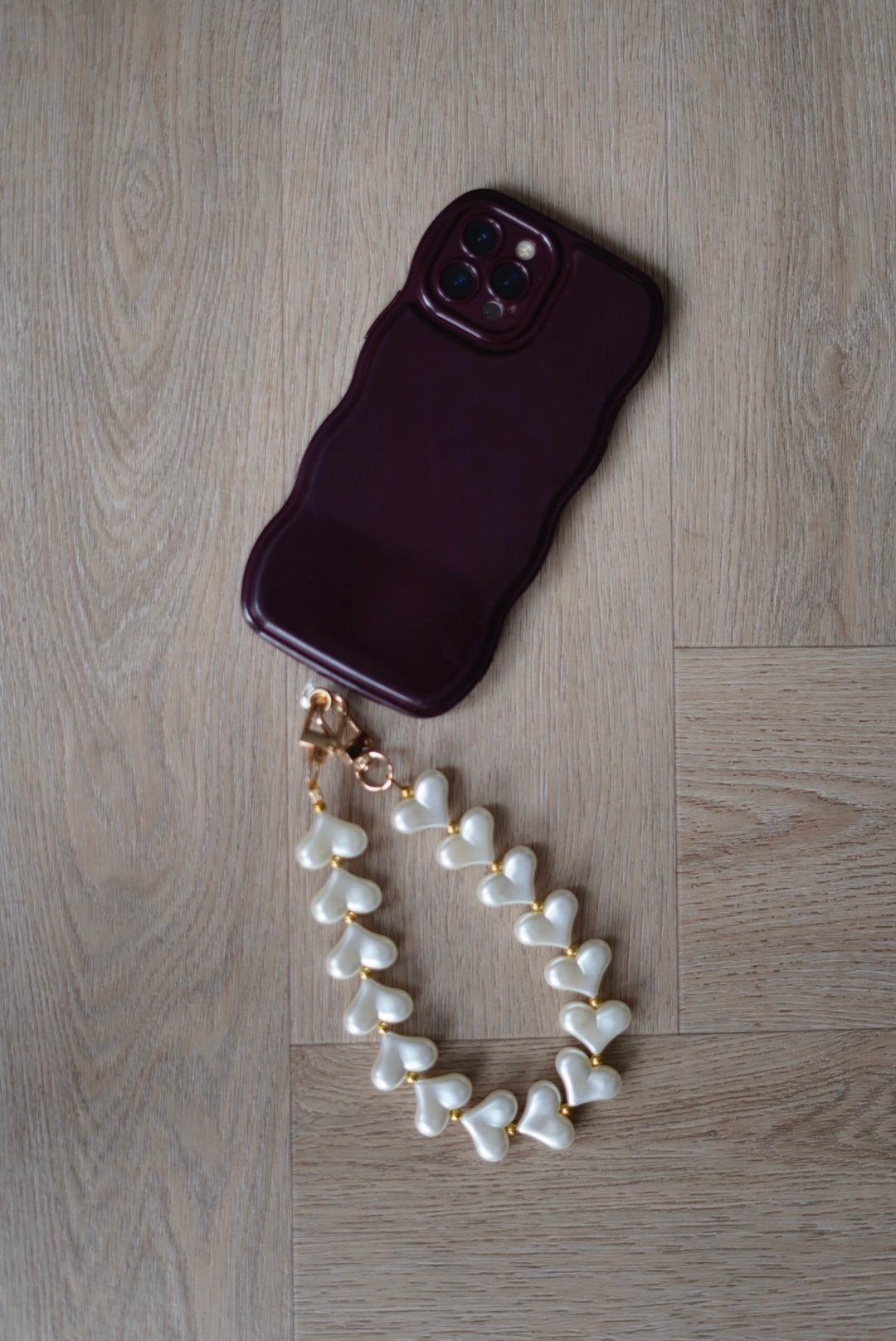 Telefoonkoord met crème parelmoer hartjes en goudkleurige details